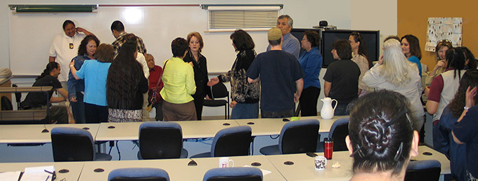 Students and professors talking in classroom.